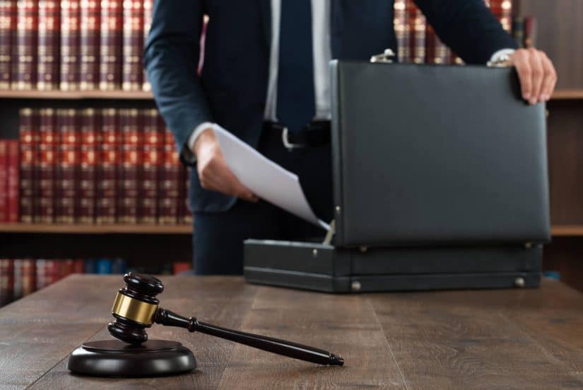Lawyer With Documents Lawyer putting documents inside their briefcase and a gavel on top of the desk