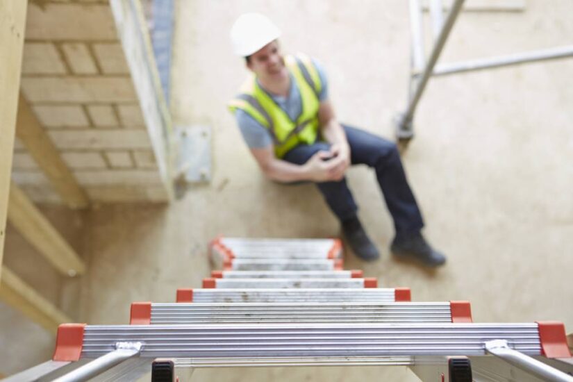 Photo of construction worker holding his knee Photo of construction worker holding his knee